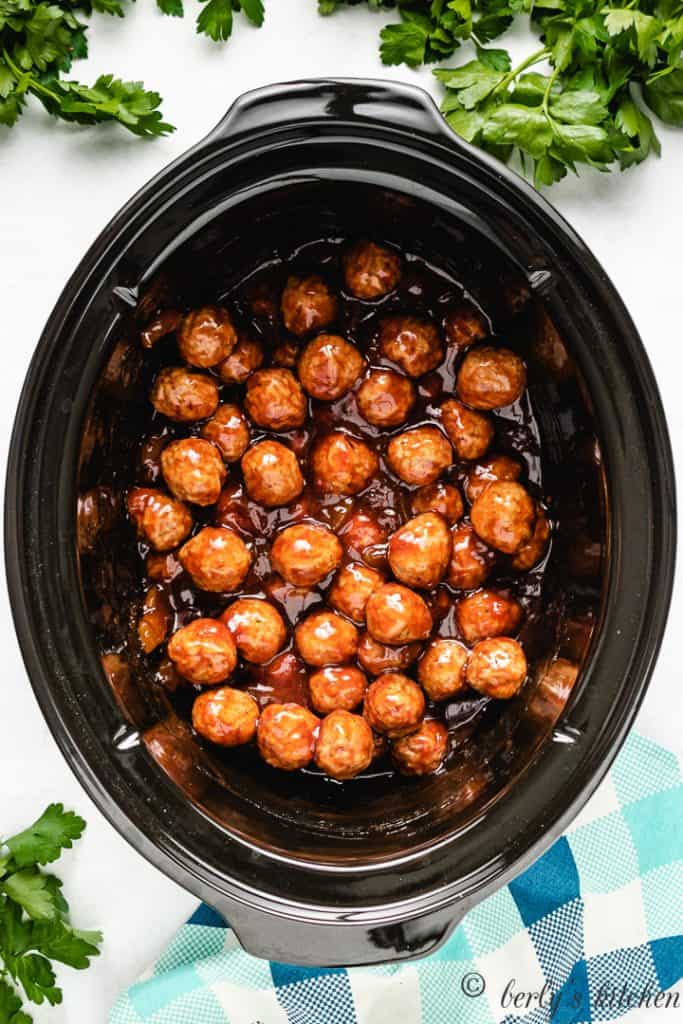 Top down view of sauced meatballs in a crock pot.