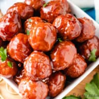 Close up of meatballs in a square bowl.