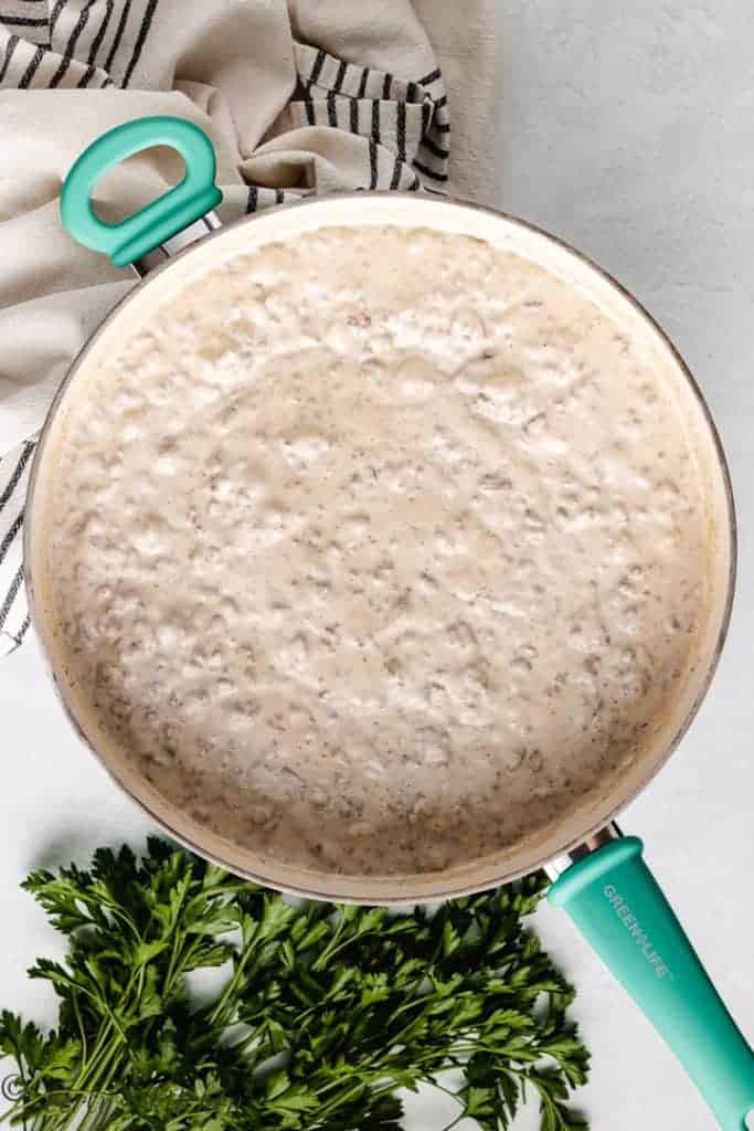 Mixed mushroom soup, french onion dip, and ground beef in a skillet.