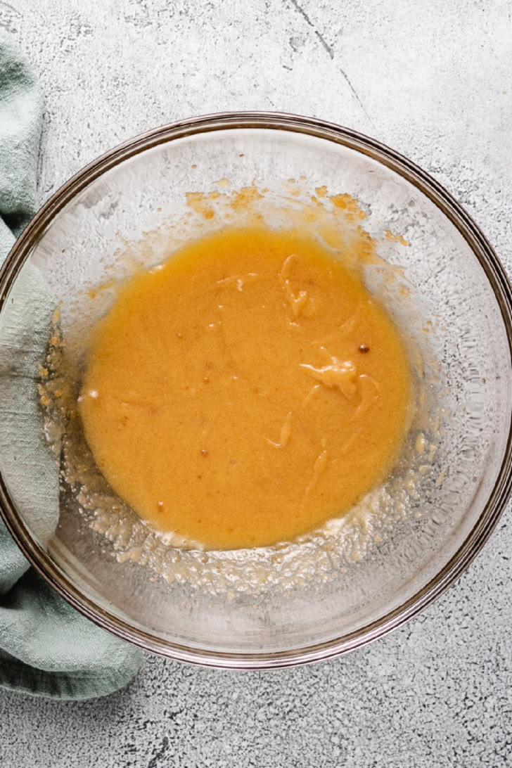 Eggs vanilla and sugar mixed in a bowl.