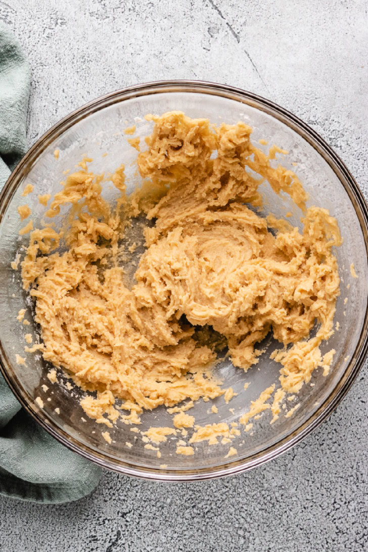 Butter, sugar, egg, and vanilla mixed in a bowl.
