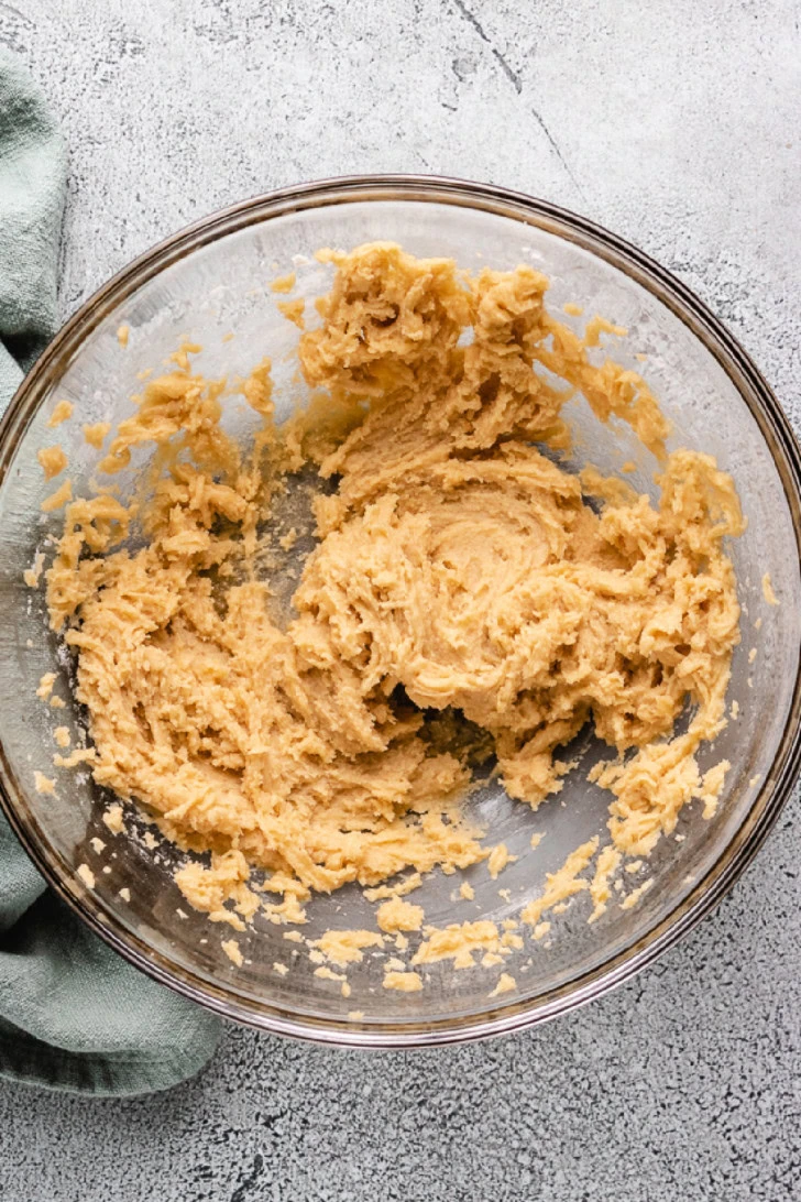 Butter, sugar, egg, and vanilla mixed in a bowl.