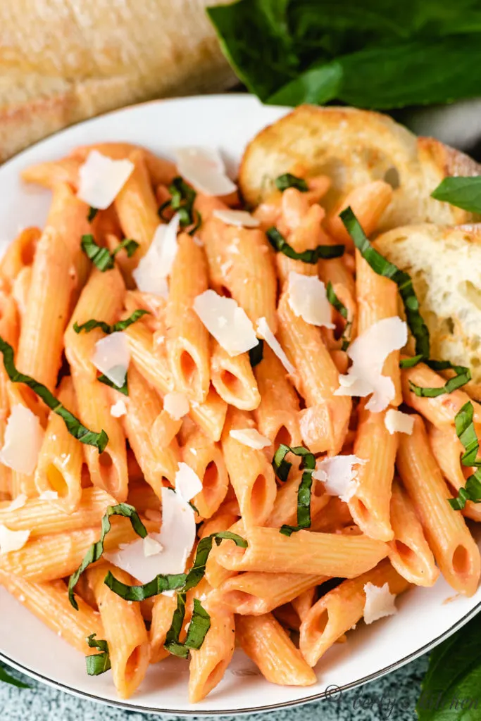 Close up of penne noodles tossed in vodka sauce.