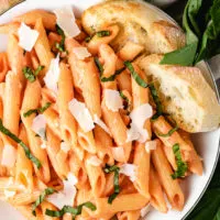 Top down view of penne with vodka sauce with bread.