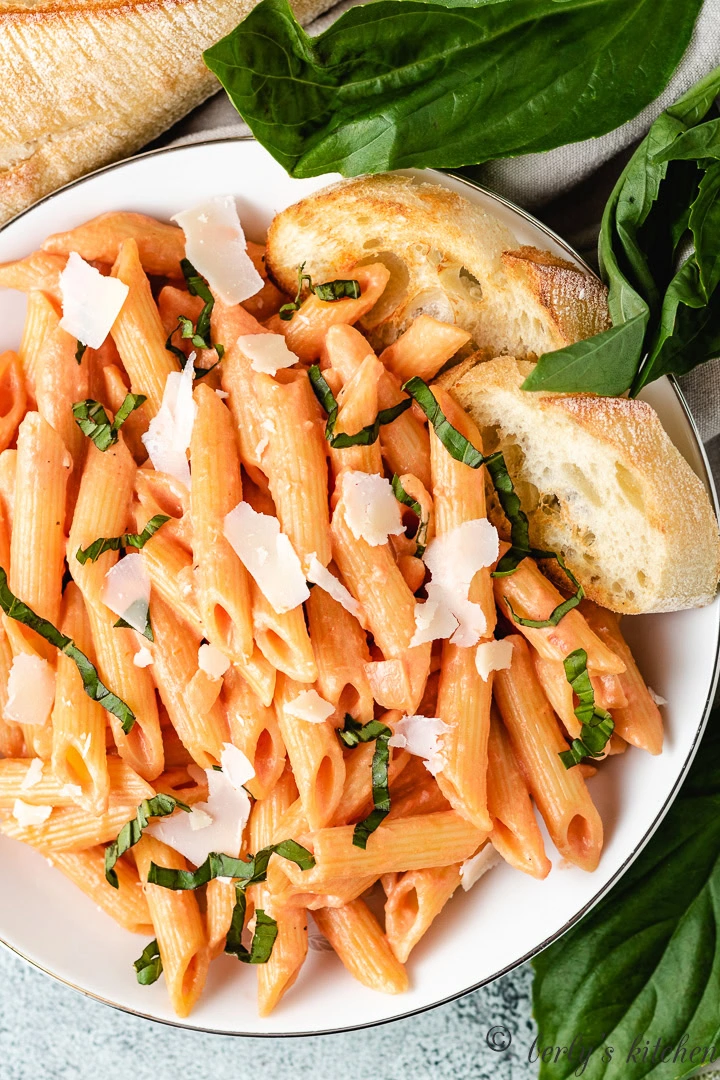 Top down view of penne with vodka sauce with bread.
