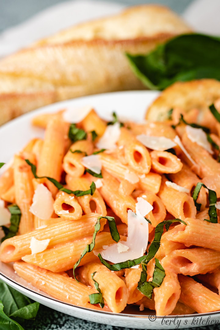 Close up of penne with vodka sauce in a white bowl.