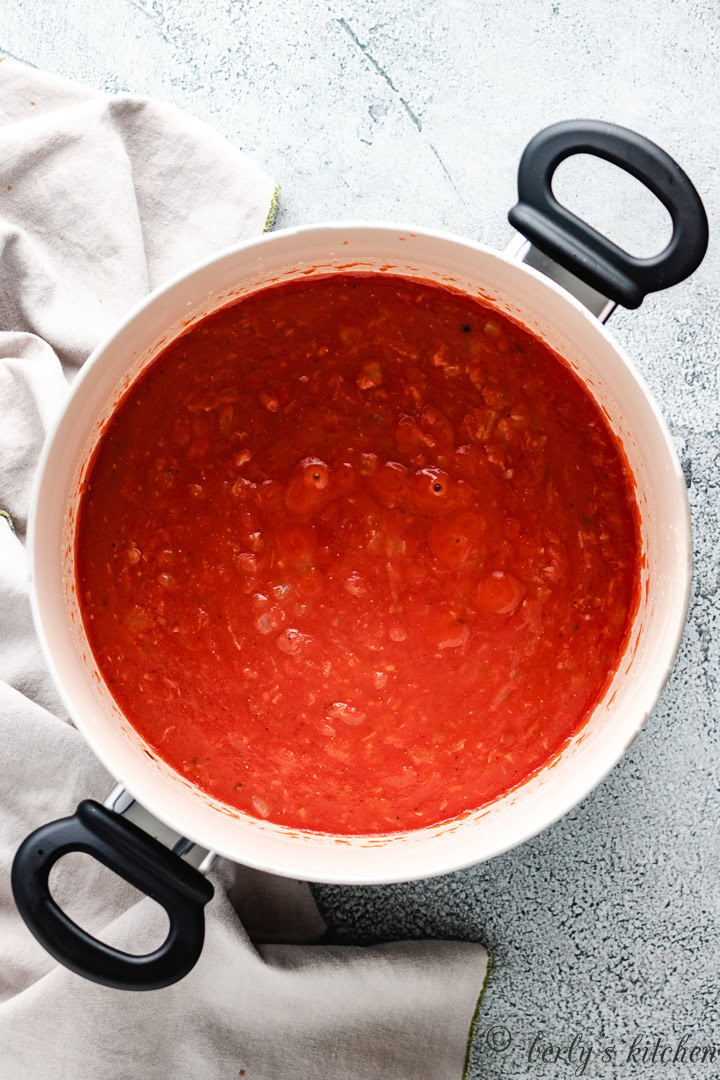 Tomatoes and sautéed onions in a pan.