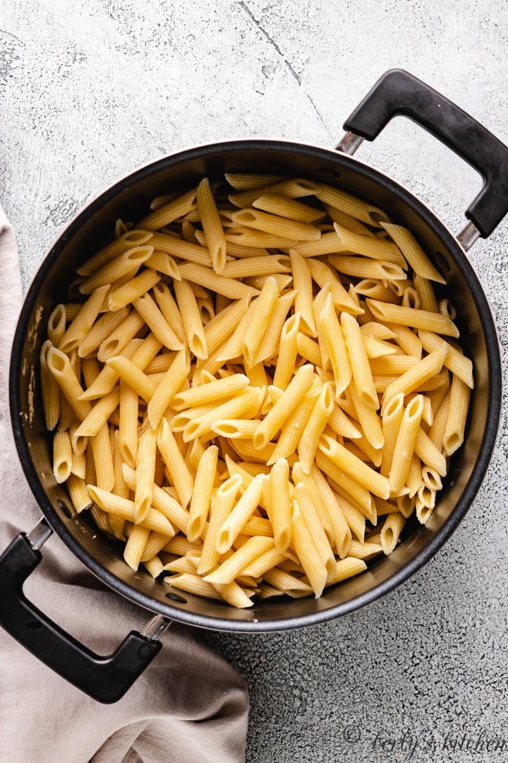 Cooked penne noodles in a pan.