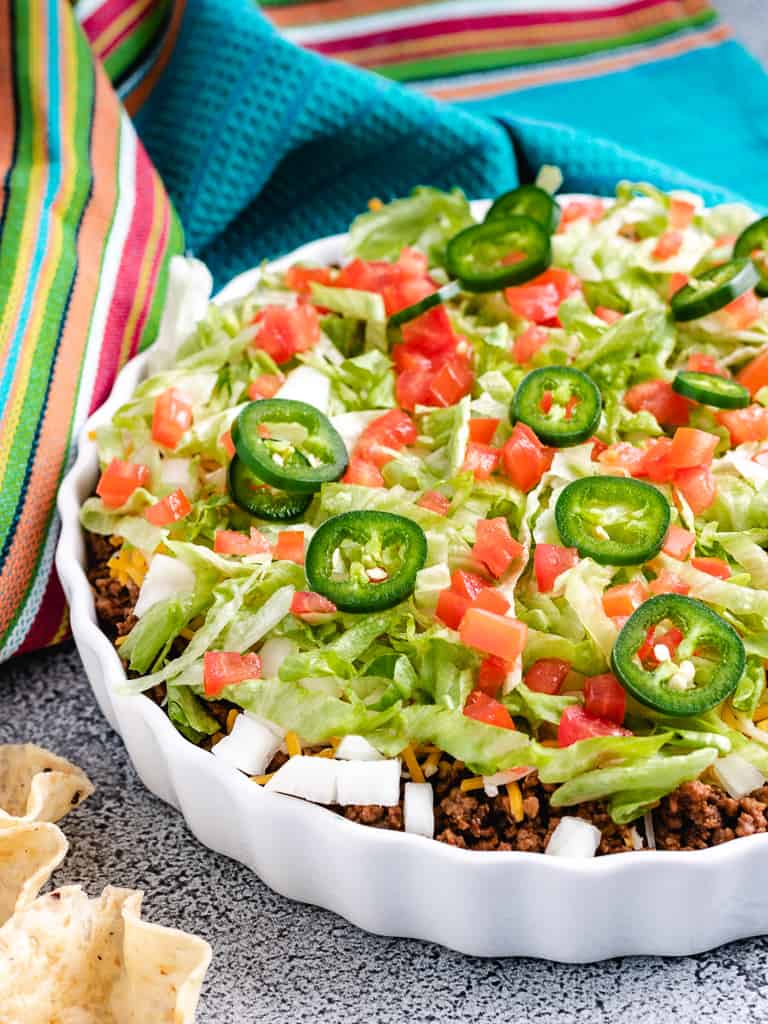 Taco dip in a white serving dish.