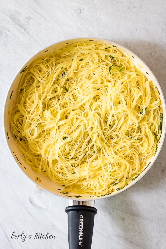 Freshly cooked pasta has been tossed with olive oil mixture.