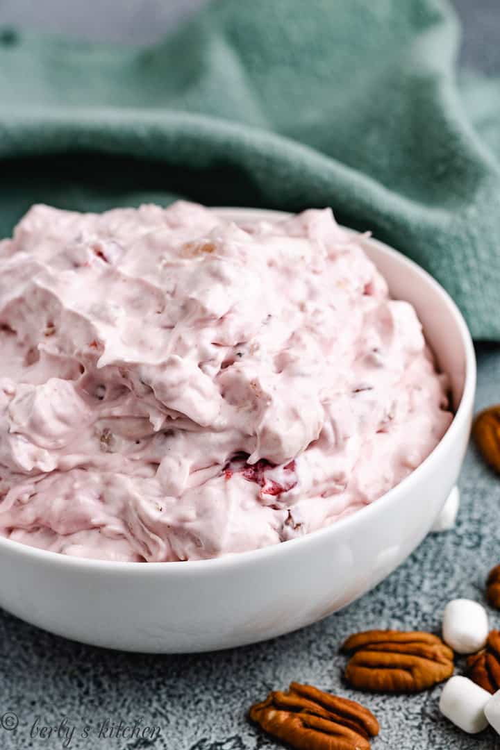 Cherry salad with whipped topping and a green towel.