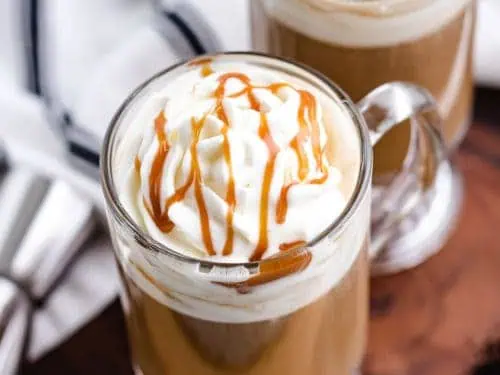 Top down view of whipped cream with caramel sauce on top of coffee.