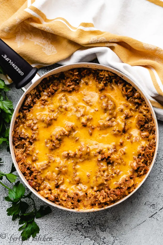 Top down view of rice, ground beef and cheese in a pan.