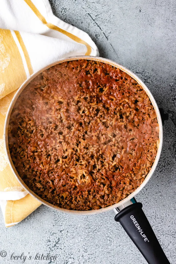 Top down view of seasoned ground beef with rice in a pan.