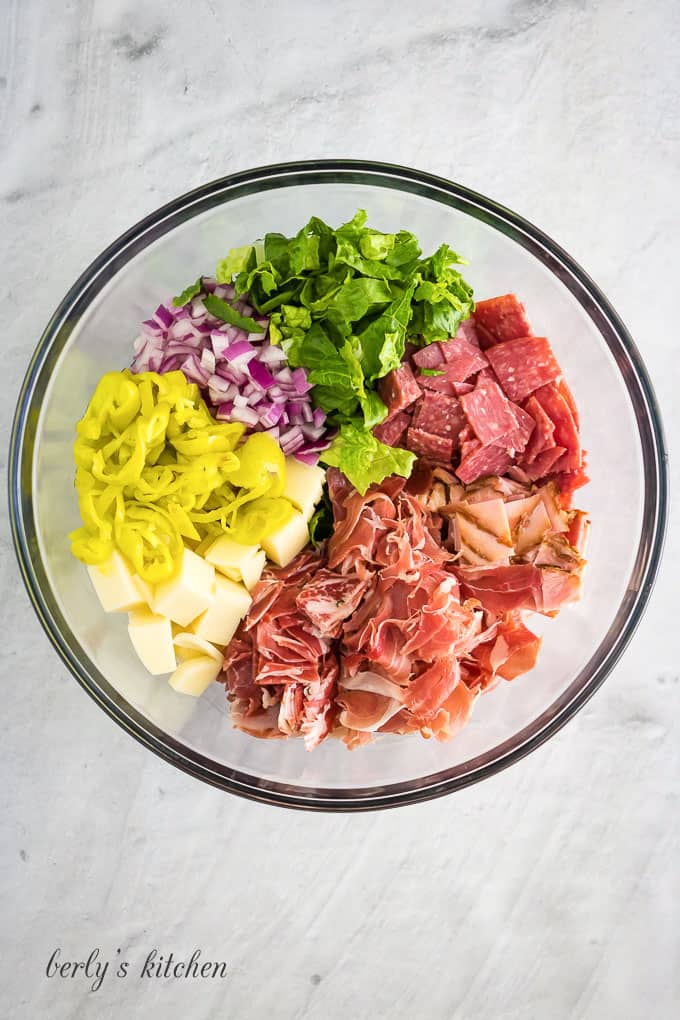 Provolone, salami, and other ingredients in a large mixing bowl.