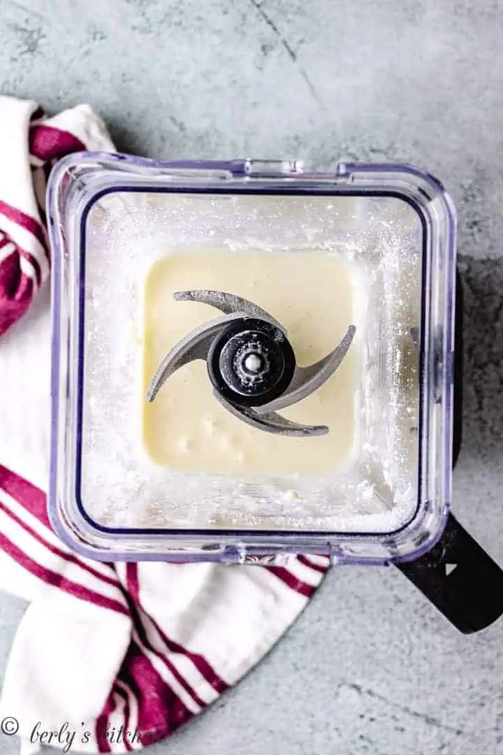 Top down view of sweetened condensed milk in a blender.