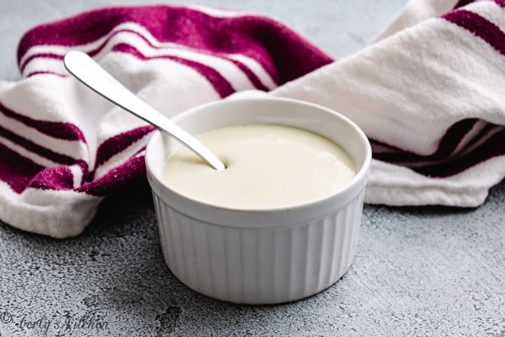 Sweetened condensed milk with a metal spoon and purple towel.