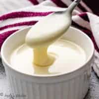 Close up view of sweetened condensed milk on a spoon.