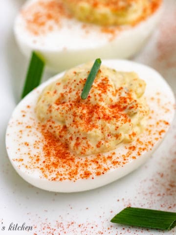 Paprika sprinkled over filled deviled egg.