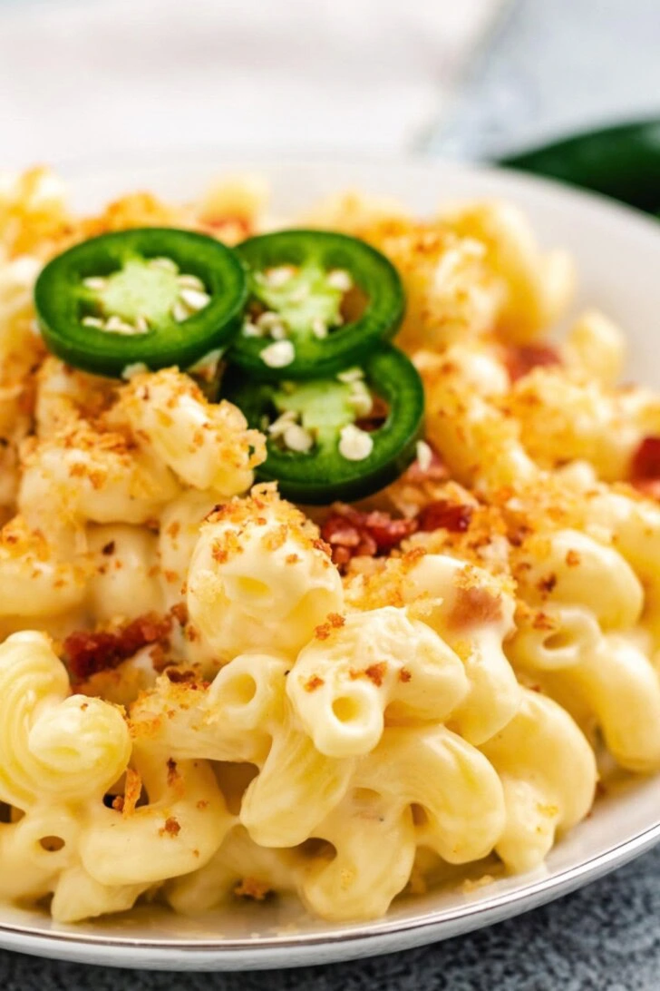 Close up view of macaroni and cheese with sliced jalapenos.