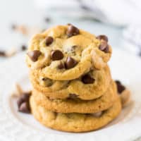 Four caramel chocolate chip cookies on a plate.