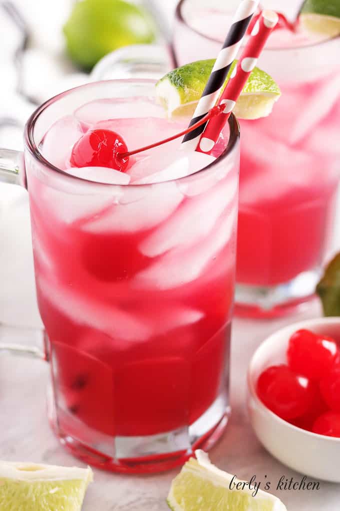 Cherry limeade served in a large mug with a colorful straw.