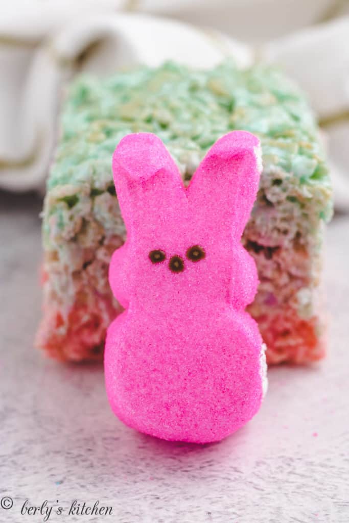 Pink peep in front of a rice krispie treat.