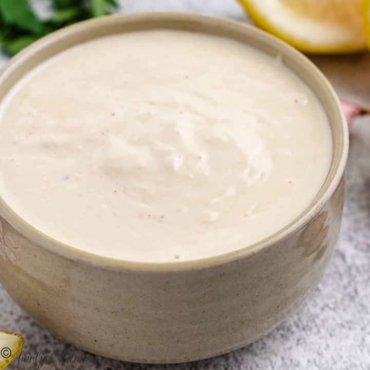 Close up of salad dressing in a tan dish.