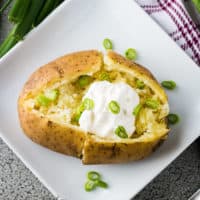 Top down view of Instant Pot baked potatoes with a scoop of sour cream.