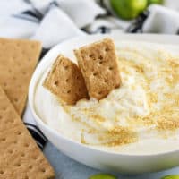 Key lime cheesecake dip, in a bowl, topped with graham cracker crumbs.