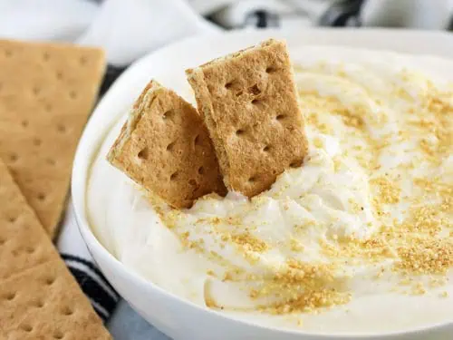 Key lime cheesecake dip, in a bowl, topped with graham cracker crumbs.