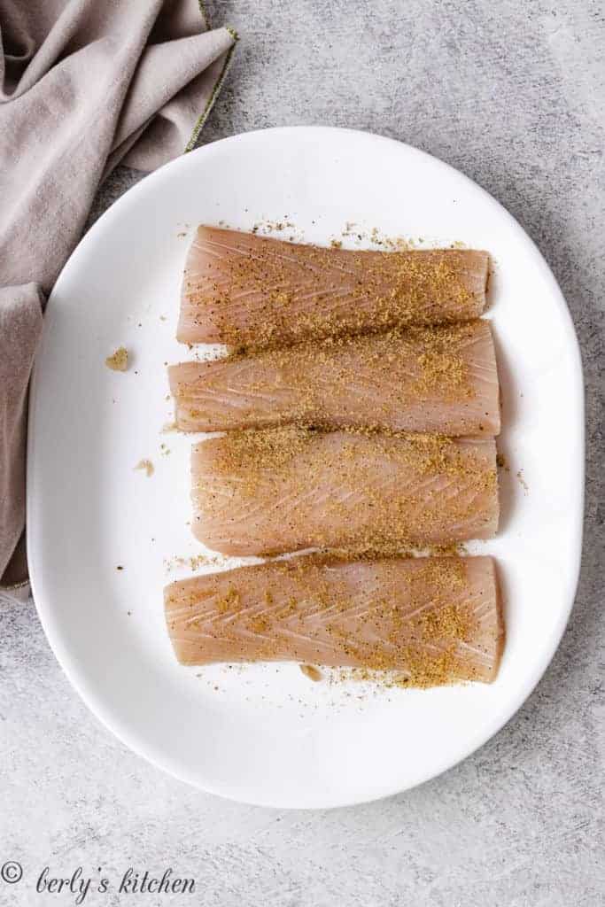 Mahi mahi fillets on a white plate.