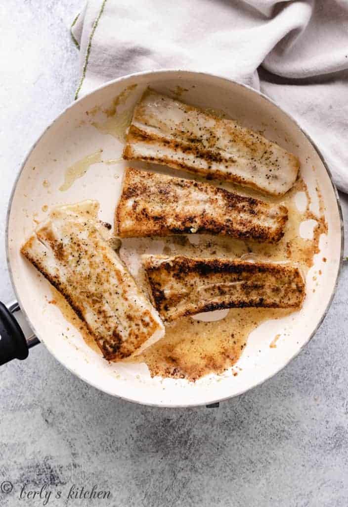 Mahi mahi cooking in a pan.