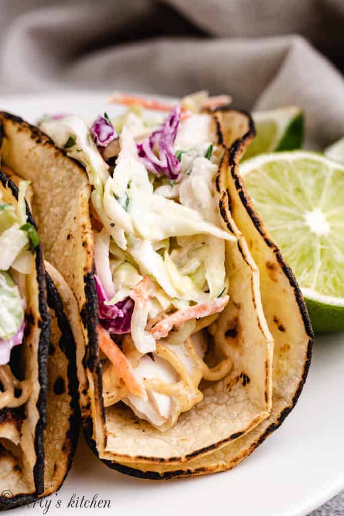 Close up of mahi mahi tacos next to a lime.