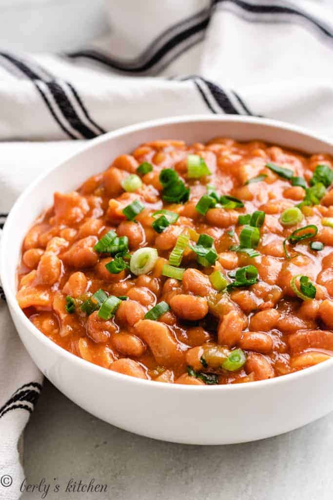 Slow cooker baked beans in a white bowl.