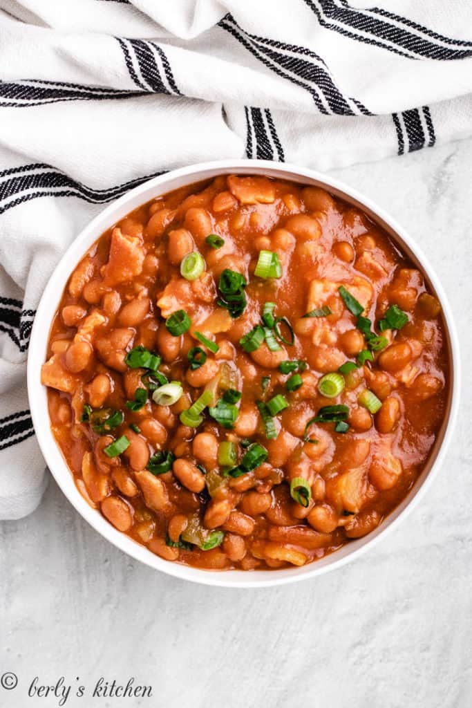 Top down view of slow cooker baked beans in a white bowl.