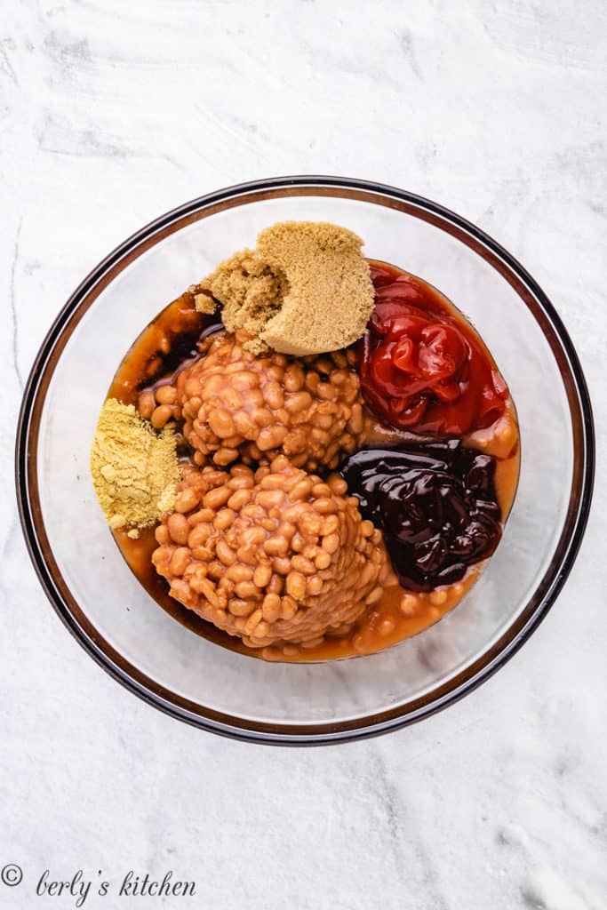 Baked beans and seasonings separated in a bowl.
