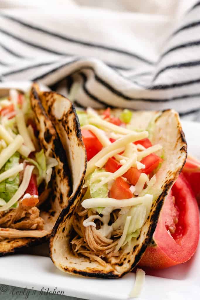Close up of slow cooker chicken tacos in a toasted tortillas.