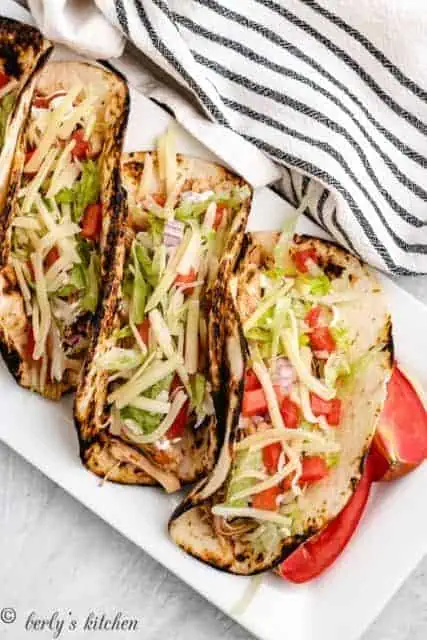 Top down view of chicken tacos in toasted tortillas.