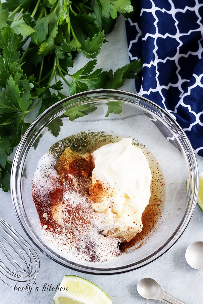 All of the ingredients for homemade dressing in a large glass bowl.