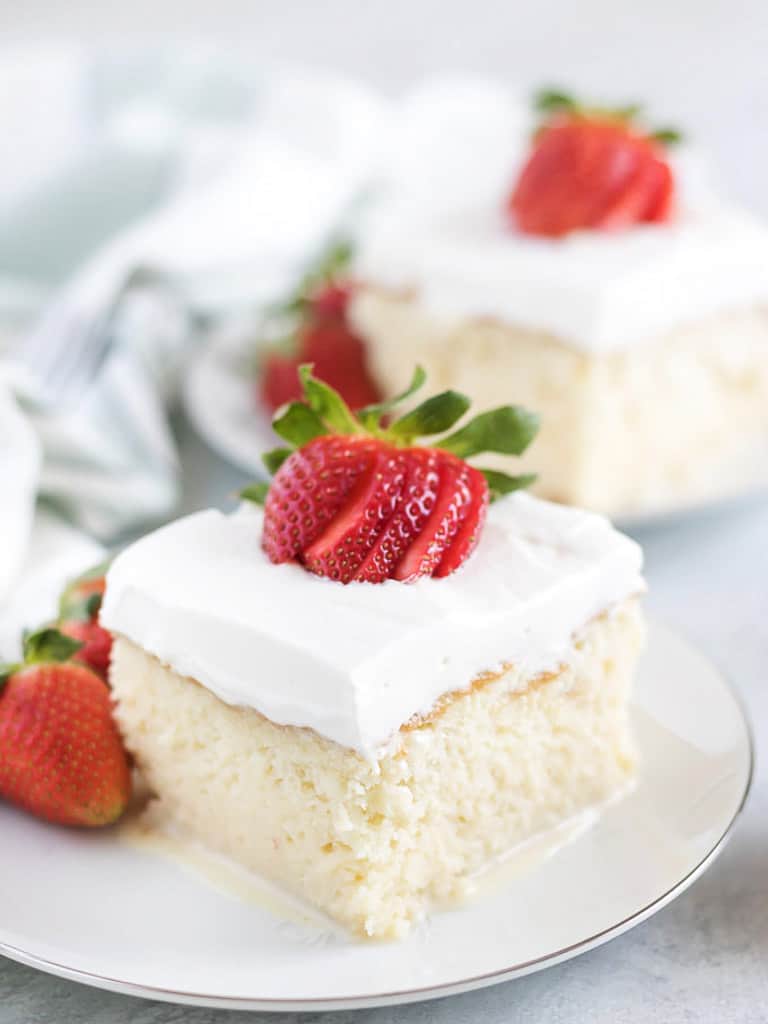 Tres leches cake on a white plate.