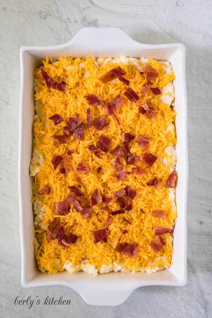 Bacon and shredded cheddar sprinkled over the casserole.