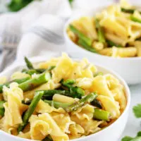 Garlic asparagus pasta in white bowls.