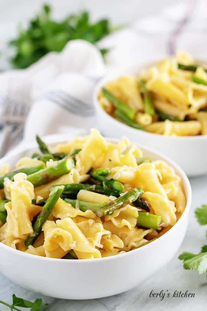 Garlic asparagus pasta in white bowls.