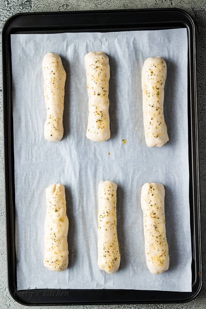 Melted garlic butter with herbs brushed across the breadsticks.