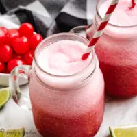 Cherry limeade slush with fresh cherries and lime wedges.