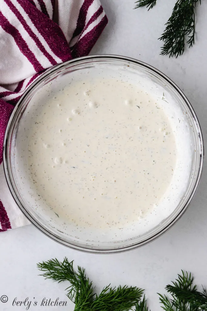 Top down view of dill dressing in a large bowl.