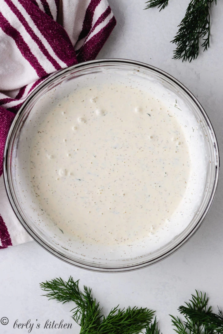 Top down view of dill dressing in a large bowl.