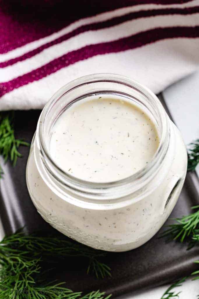 Top down view of dill dressing in a jar.