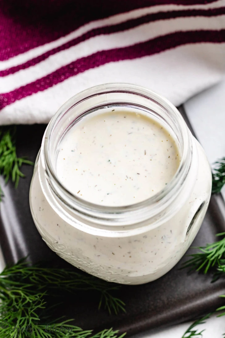 Top down view of dill dressing in a jar.